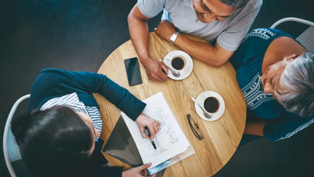 Diverse individuals exploring life insurance options on digital devices highlighting modern consumer engagement